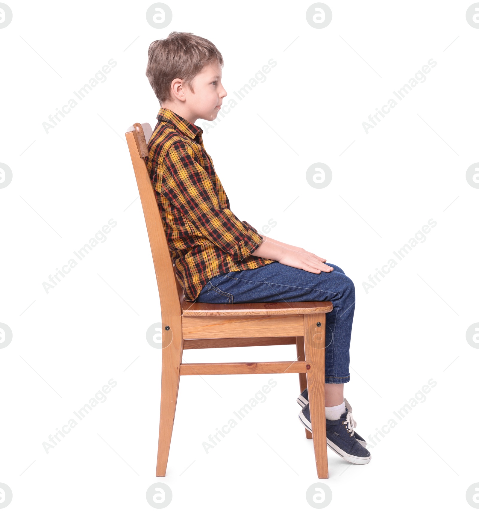 Photo of Boy with correct posture sitting on chair against white background