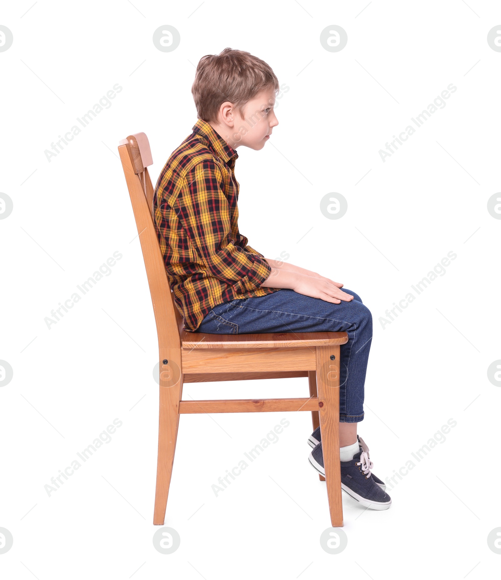 Photo of Boy with incorrect posture sitting on chair against white background