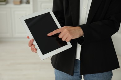 Photo of Businesswoman using tablet indoors, closeup. Modern technology