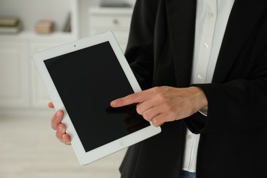 Photo of Businesswoman using tablet indoors, closeup. Modern technology