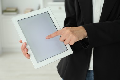 Photo of Businesswoman using tablet indoors, closeup. Modern technology