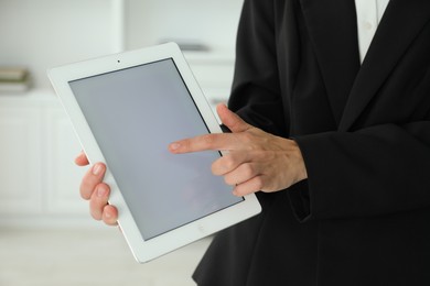 Photo of Businesswoman using tablet indoors, closeup. Modern technology