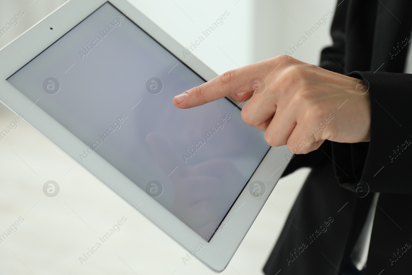 Photo of Businesswoman using tablet indoors, closeup. Modern technology