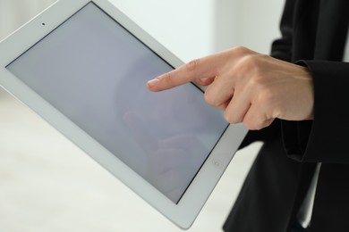 Photo of Businesswoman using tablet indoors, closeup. Modern technology