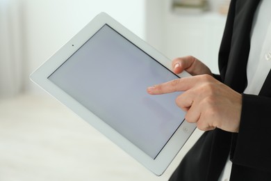 Photo of Businesswoman using tablet indoors, closeup. Modern technology