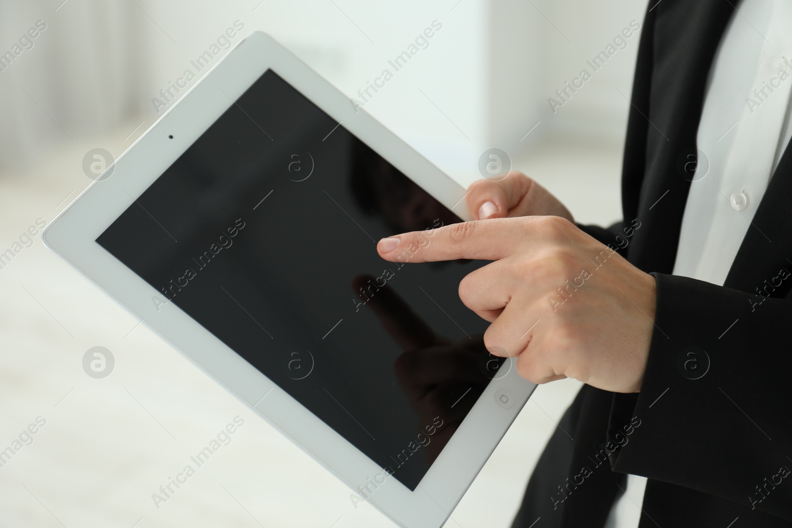 Photo of Businesswoman using tablet indoors, closeup. Modern technology