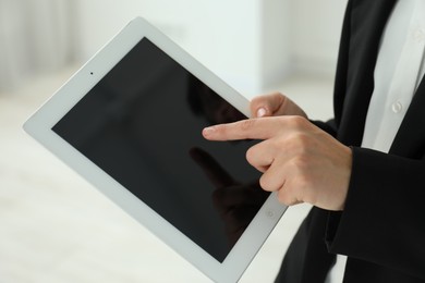 Photo of Businesswoman using tablet indoors, closeup. Modern technology