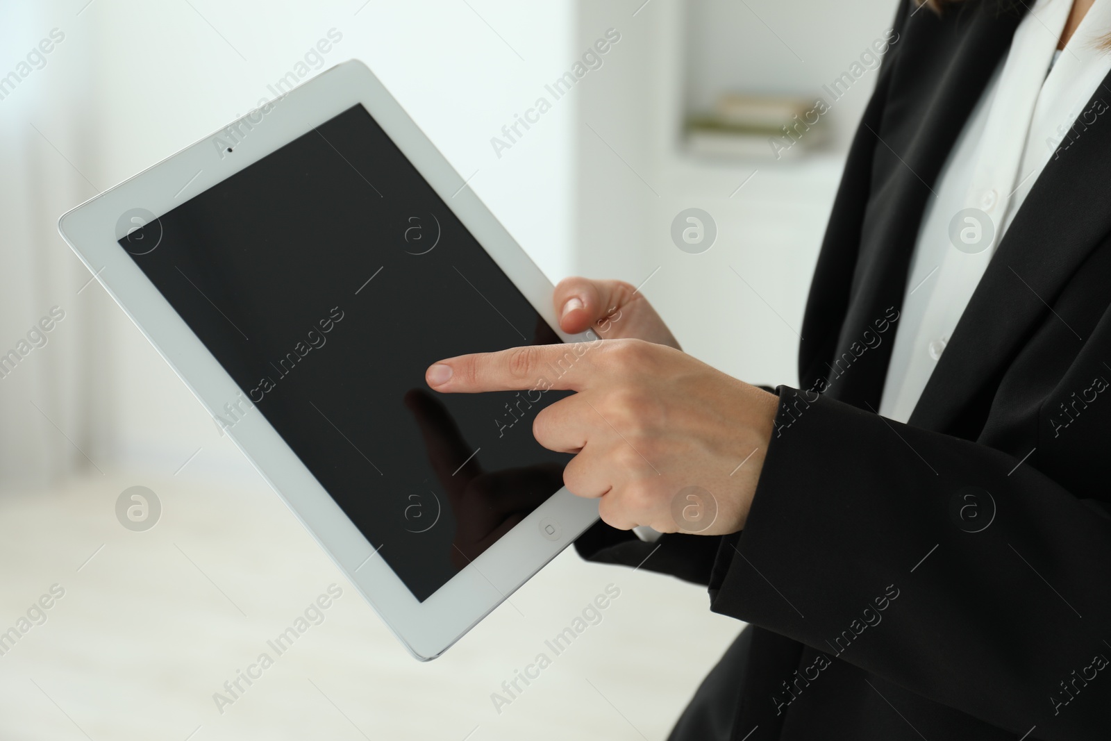 Photo of Businesswoman using tablet indoors, closeup. Modern technology