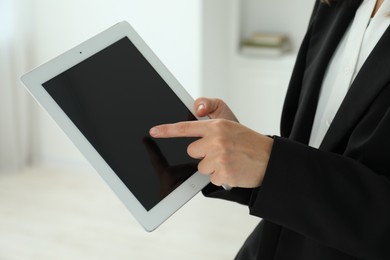 Photo of Businesswoman using tablet indoors, closeup. Modern technology