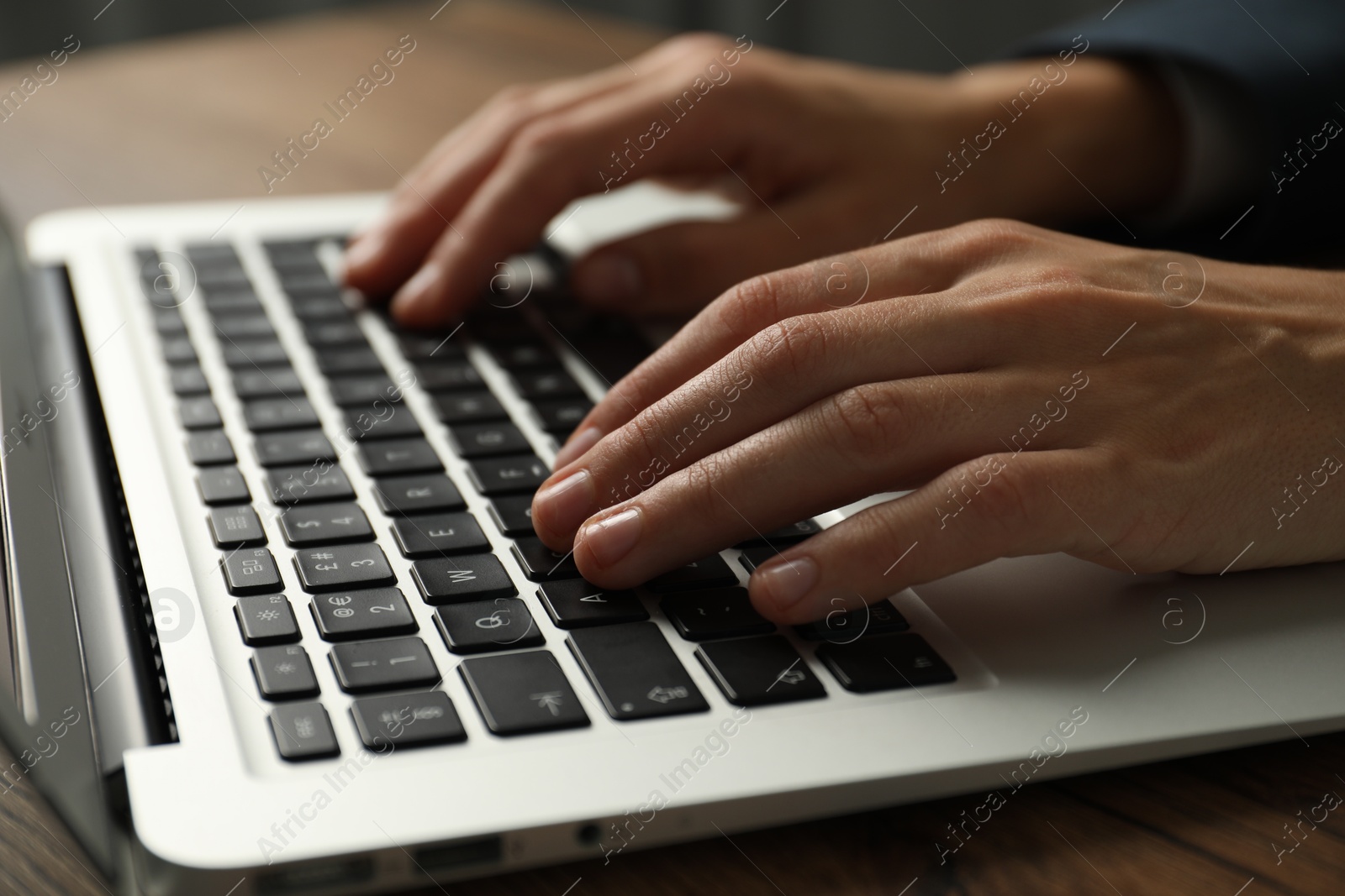 Photo of Businesswoman using laptop at table indoors, closeup. Modern technology