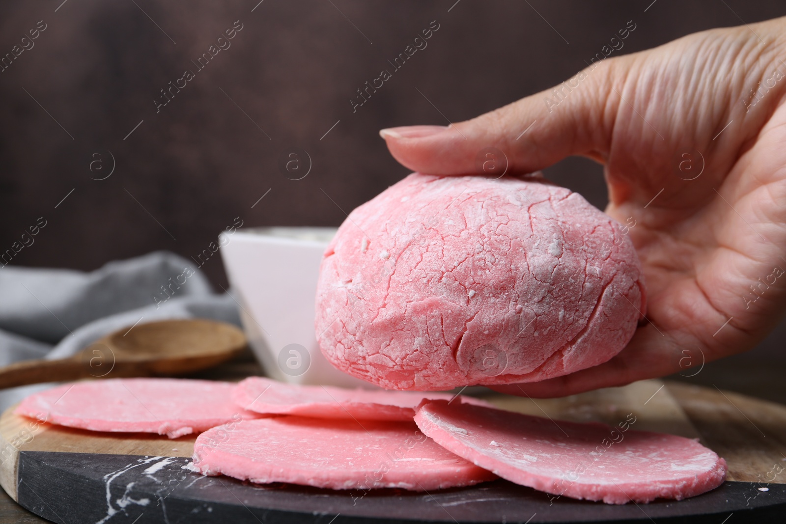 Photo of Woman making tasty mochi at wooden table, closeup