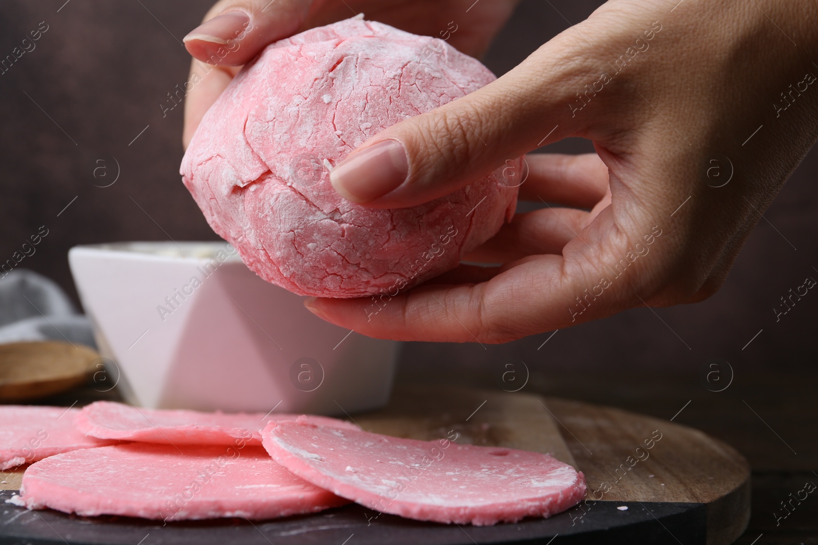 Photo of Woman making tasty mochi at wooden table, closeup