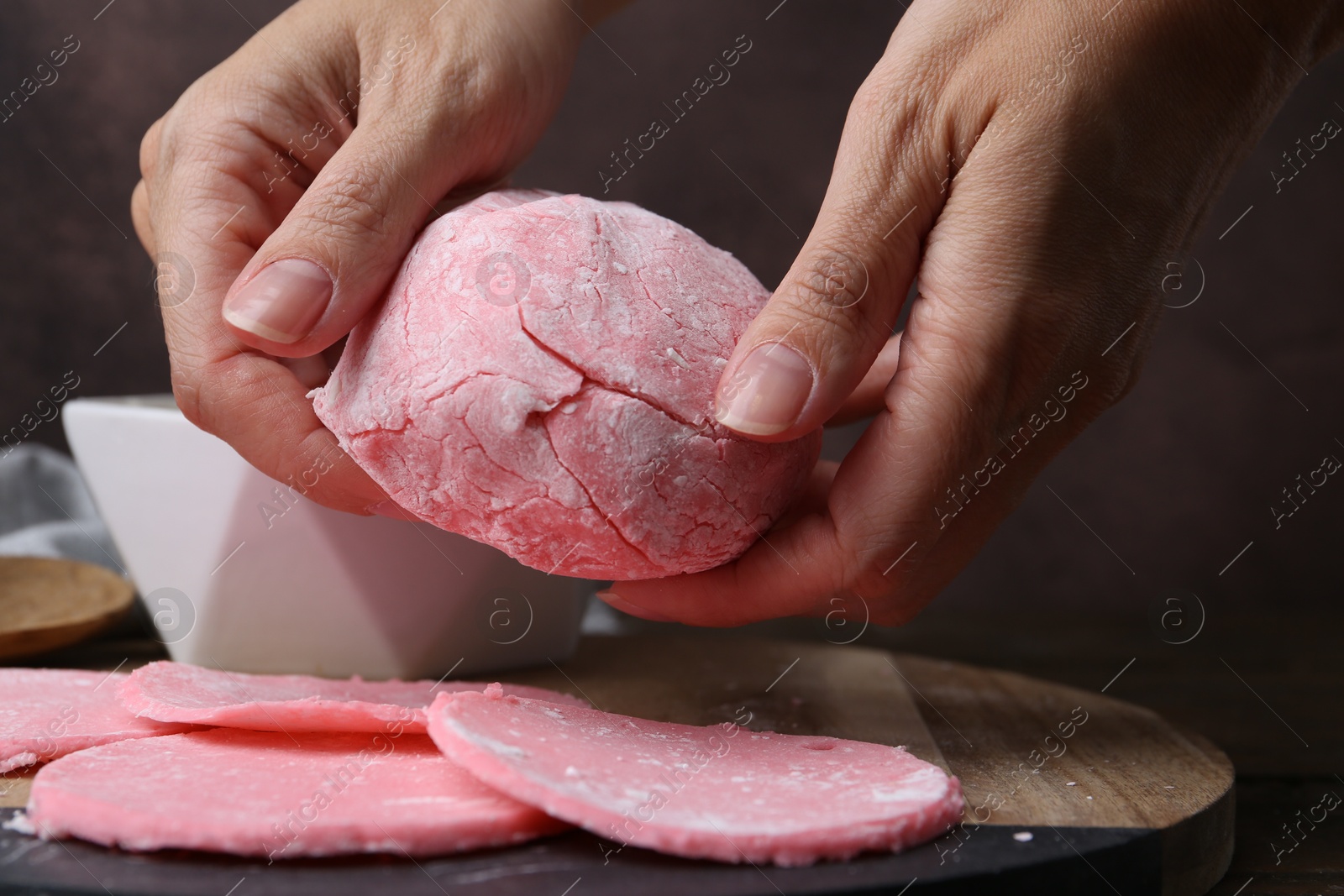 Photo of Woman making tasty mochi at wooden table, closeup