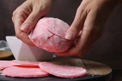 Photo of Woman making tasty mochi at wooden table, closeup