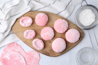 Photo of Tasty homemade mochi on white tiled table, top view