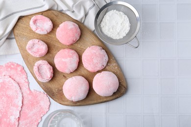 Photo of Tasty homemade mochi on white tiled table, top view. Space for text