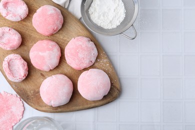 Tasty homemade mochi on white tiled table, top view. Space for text