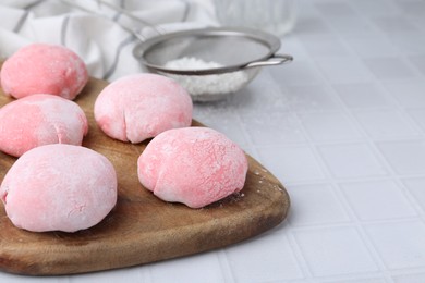 Photo of Tasty homemade mochi on white tiled table, closeup