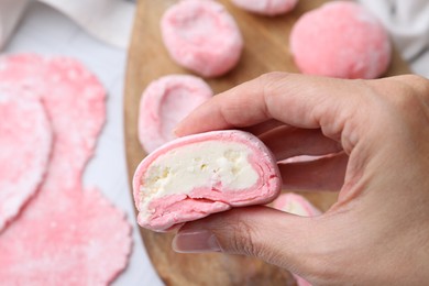 Photo of Woman making tasty mochi at white table, closeup