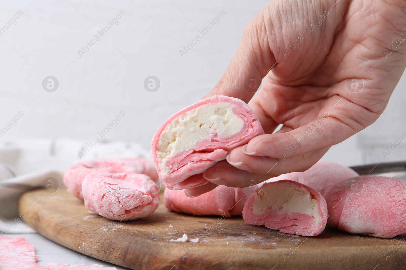 Photo of Woman making tasty mochi at white table, closeup