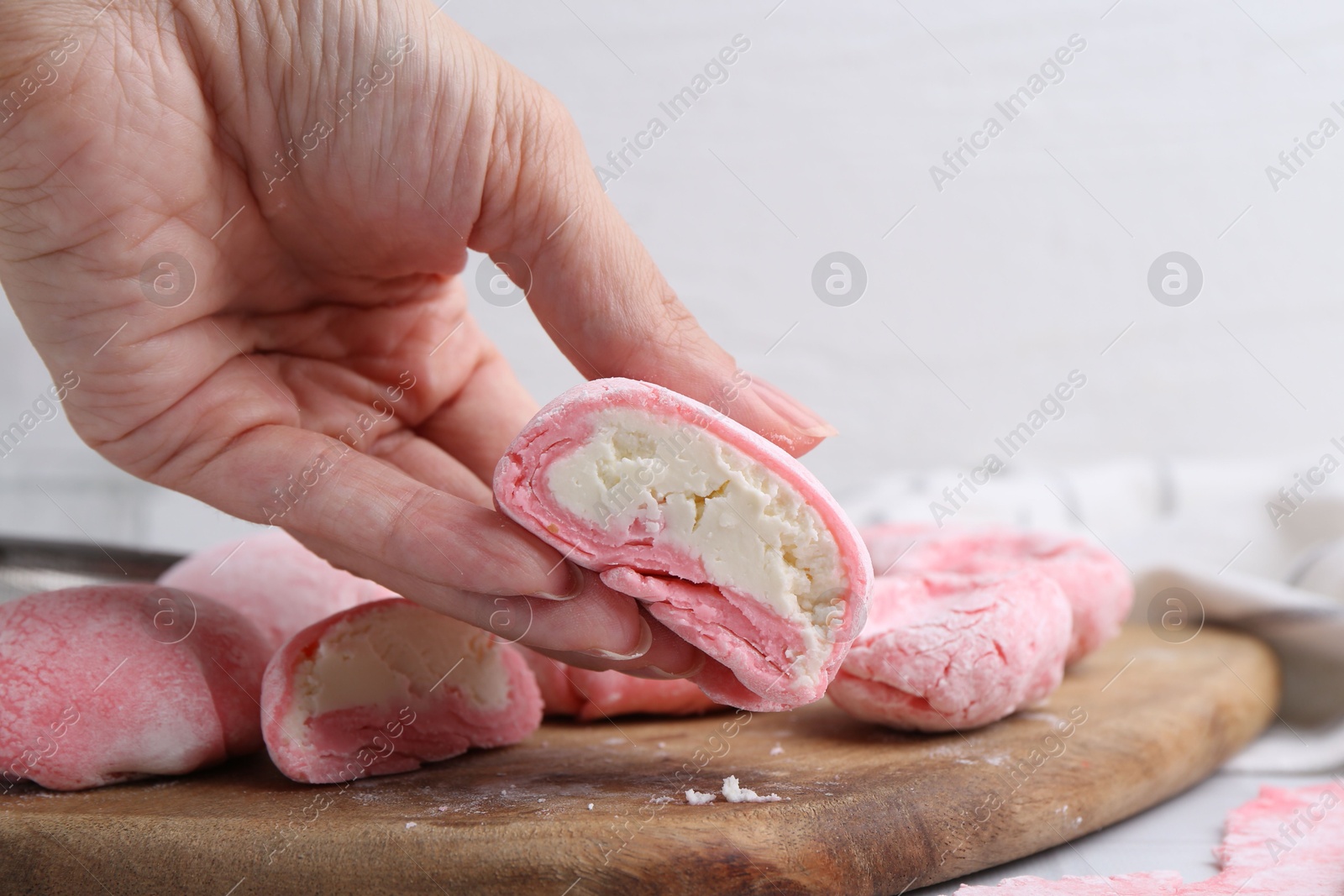 Photo of Woman making tasty mochi at white table, closeup