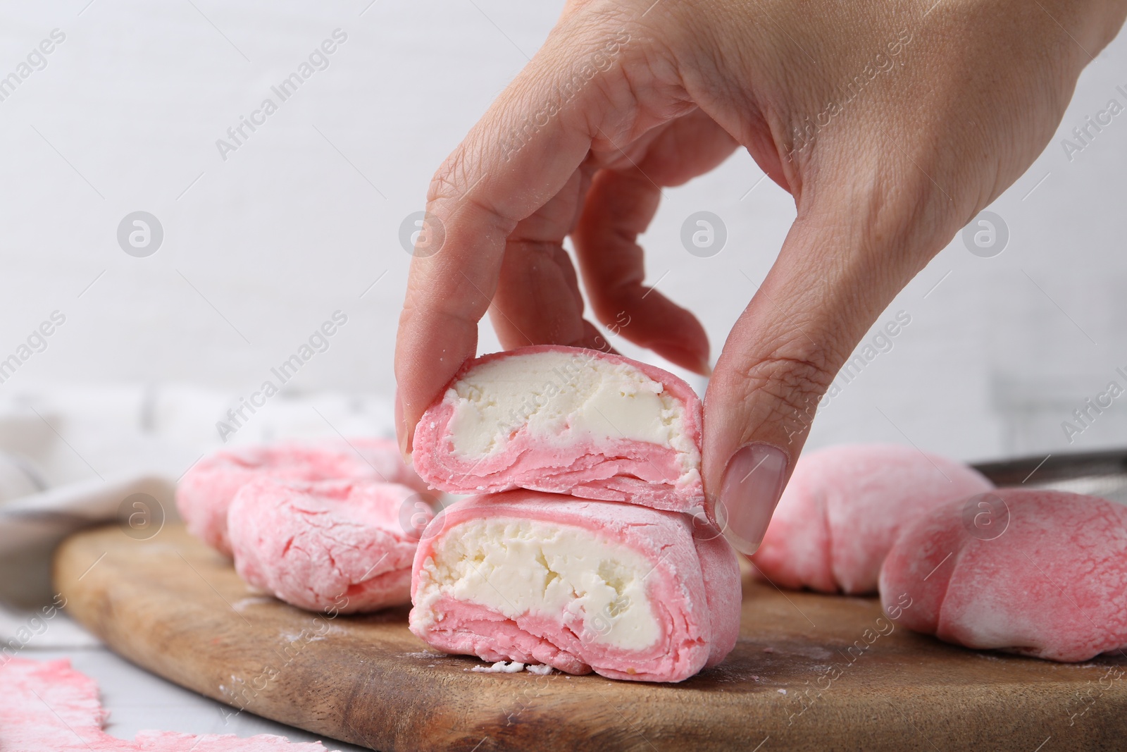 Photo of Woman making tasty mochi at white table, closeup