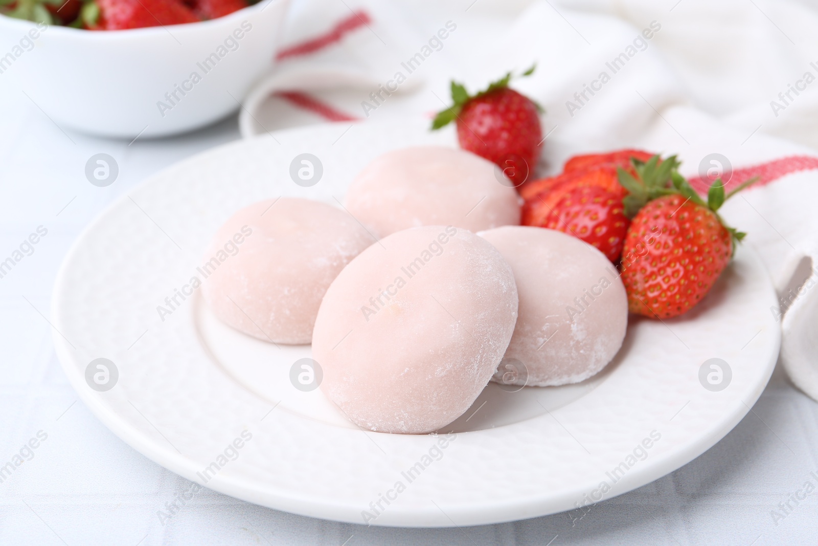 Photo of Delicious mochi and strawberries on table, closeup