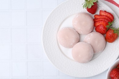 Photo of Delicious mochi and strawberries on white tiled table, top view. Space for text