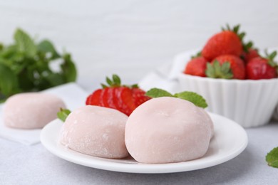 Delicious mochi, strawberries and mint on light grey table, closeup