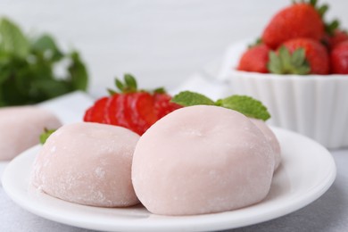 Photo of Delicious mochi, strawberries and mint on table, closeup