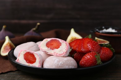 Delicious mochi with strawberries and figs on wooden table, closeup