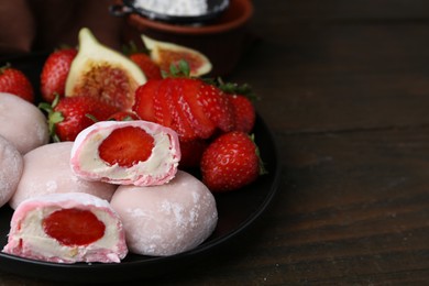 Photo of Delicious mochi with strawberries and figs on wooden table, closeup