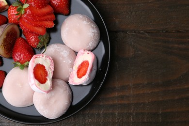 Delicious mochi with strawberries and fig on wooden table, top view. Space for text