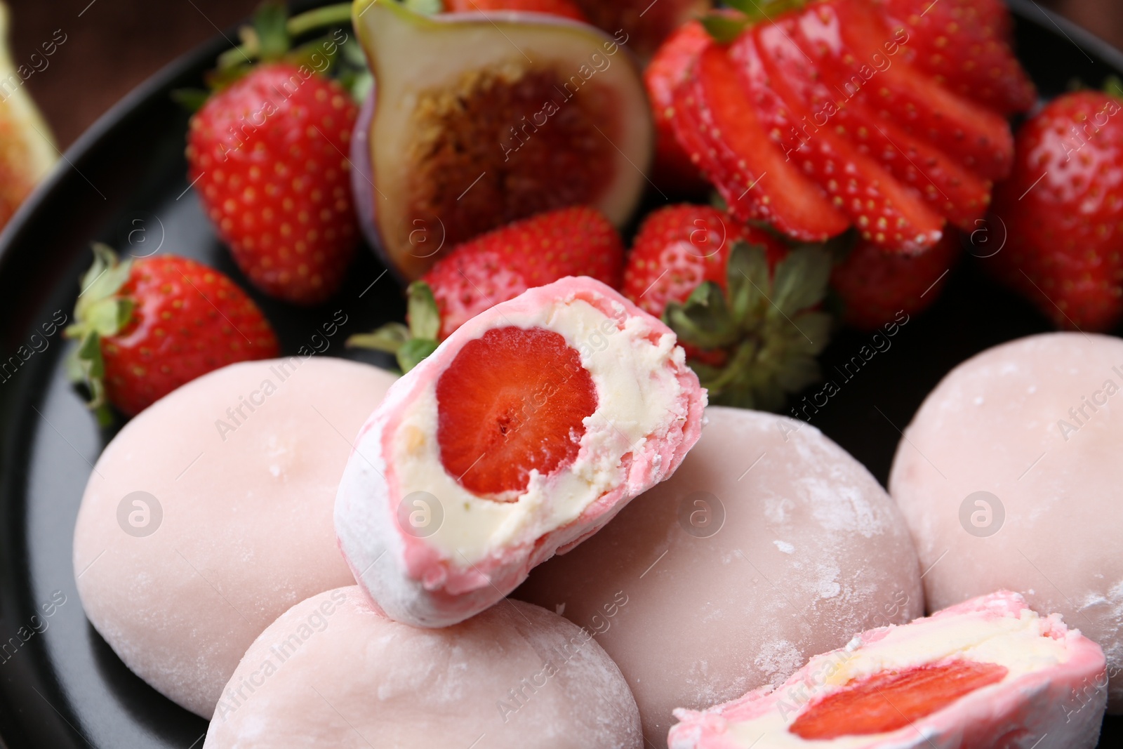 Photo of Delicious mochi with strawberries and fig on plate, closeup