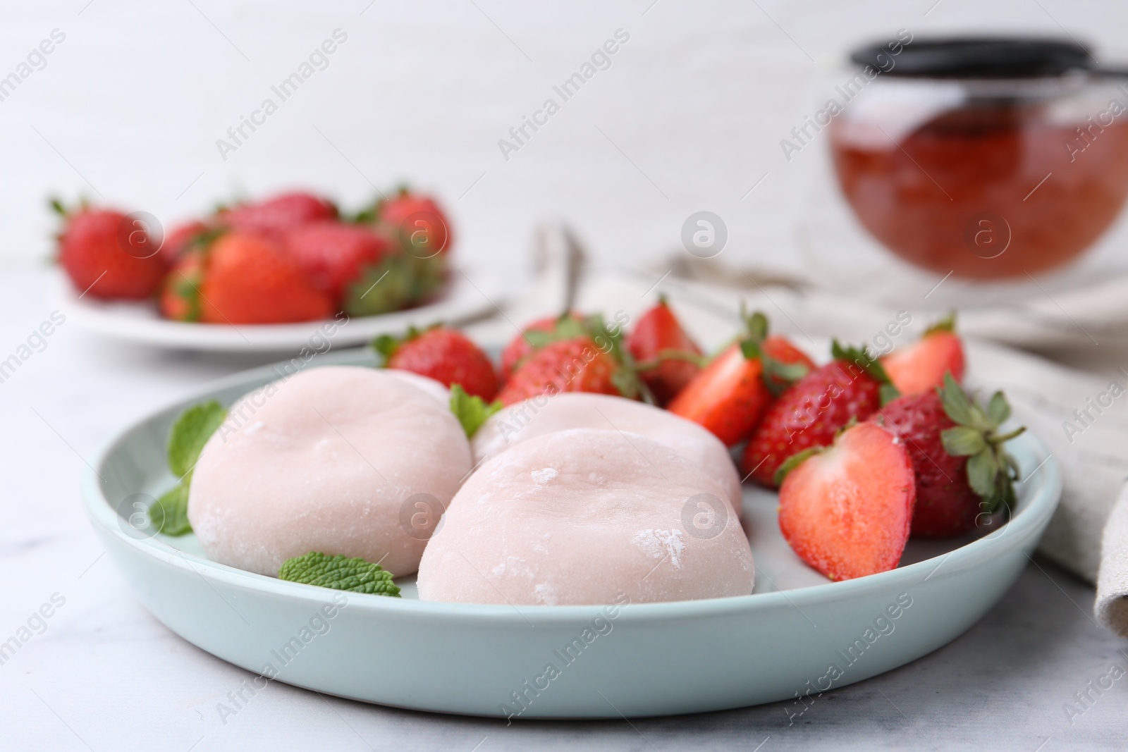 Photo of Delicious mochi, strawberries and mint on table, closeup