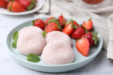 Photo of Delicious mochi, strawberries and mint on table, closeup