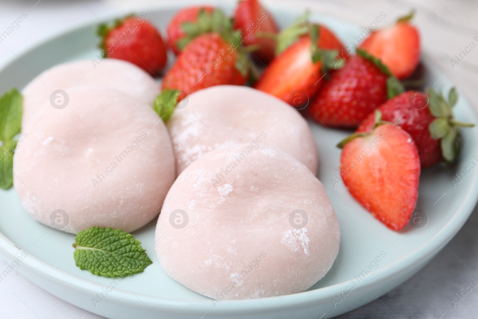 Photo of Delicious mochi, strawberries and mint on table, closeup