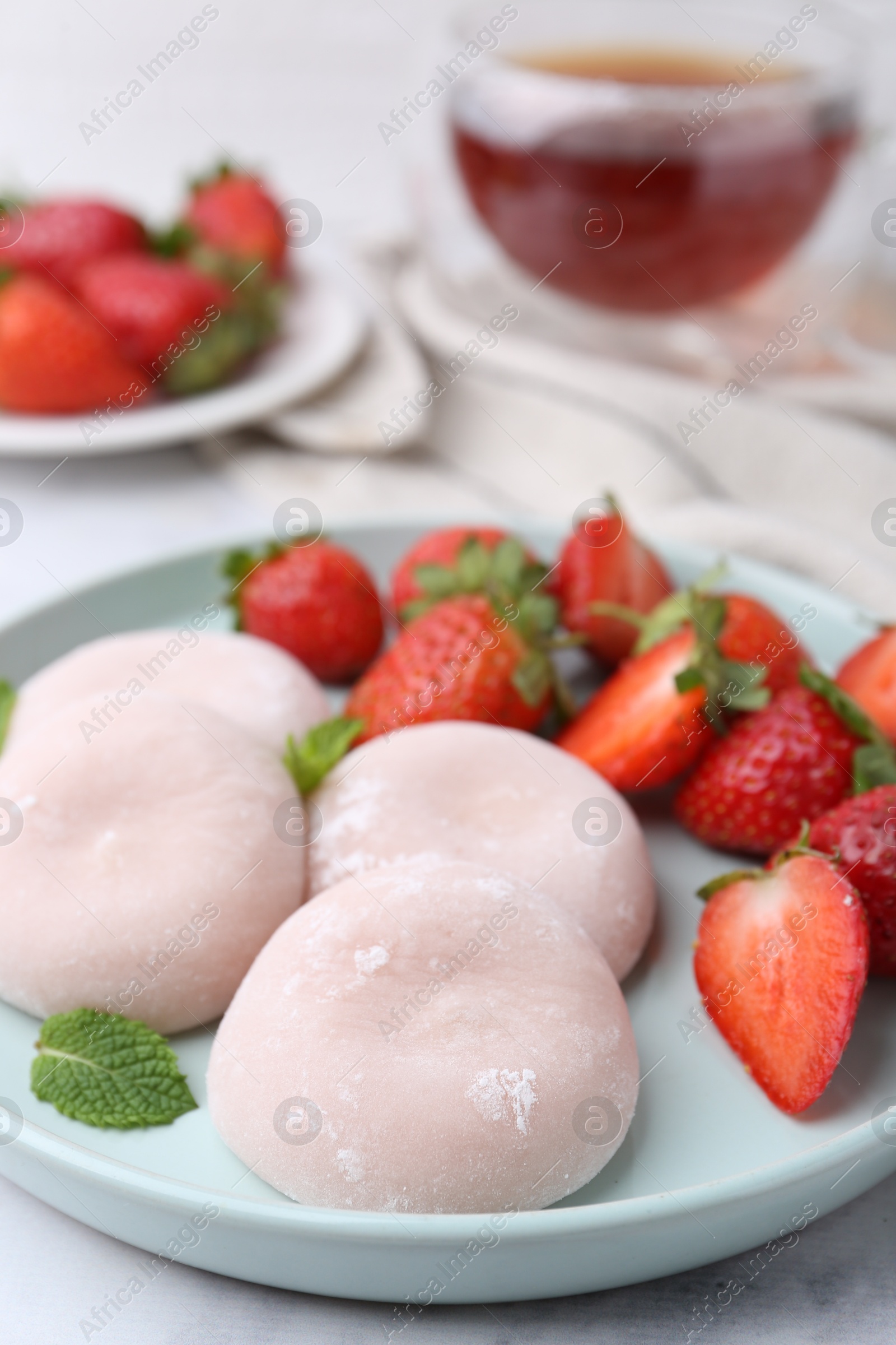 Photo of Delicious mochi, strawberries and mint on table, closeup