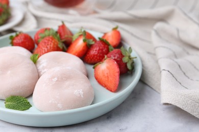 Delicious mochi, strawberries and mint on white marble table, closeup