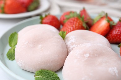 Photo of Delicious mochi, strawberries and mint on table, closeup