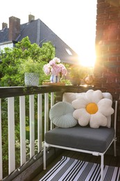 Photo of Different plants on railings and chair at cozy balcony outdoors