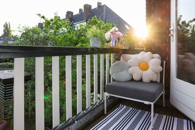 Different plants on railings and chair at cozy balcony outdoors