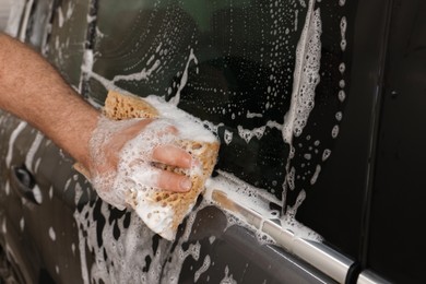 Man washing auto with sponge at car wash, closeup