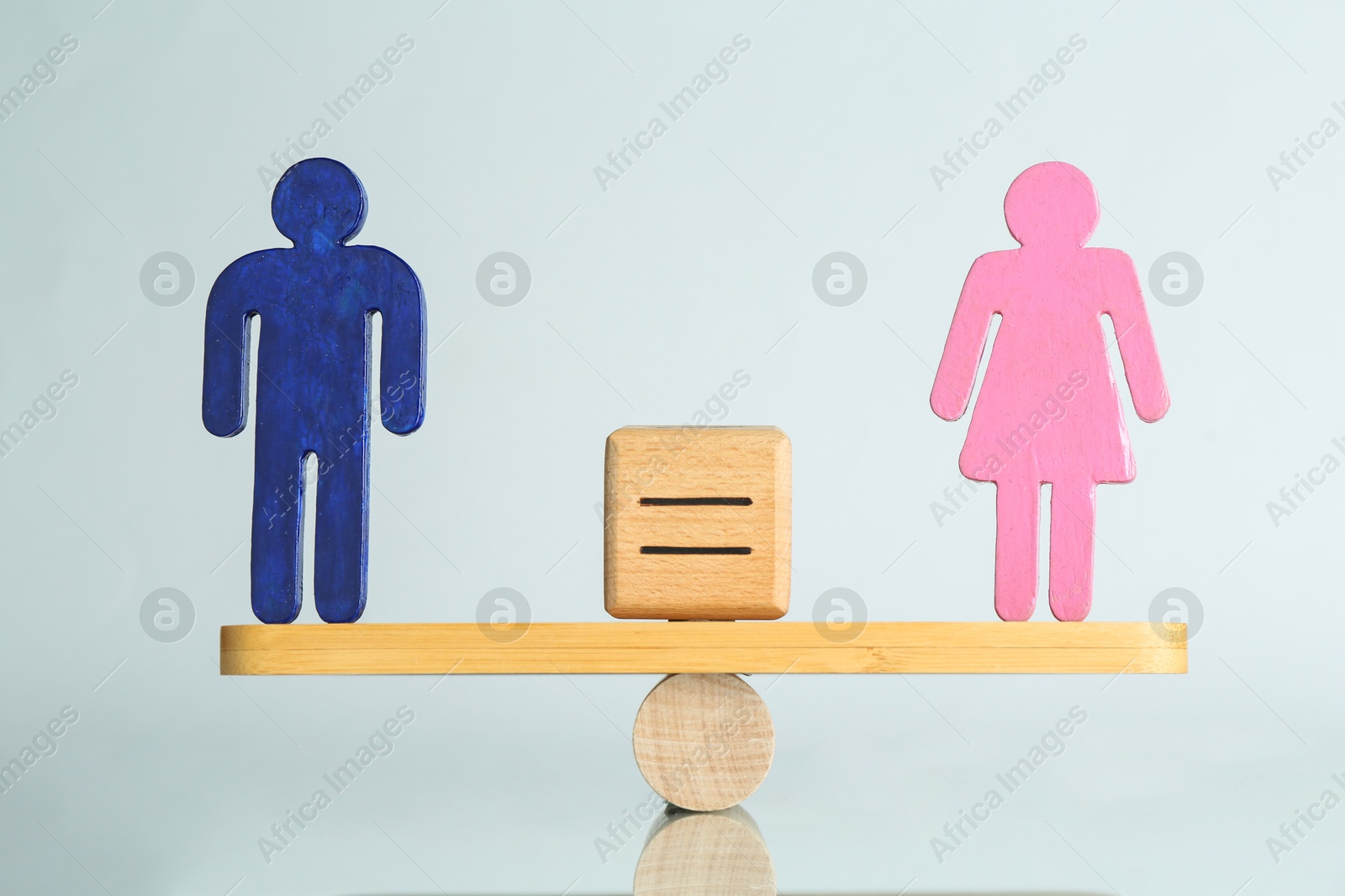 Photo of Gender equality concept. Male and female figures on scales against light background