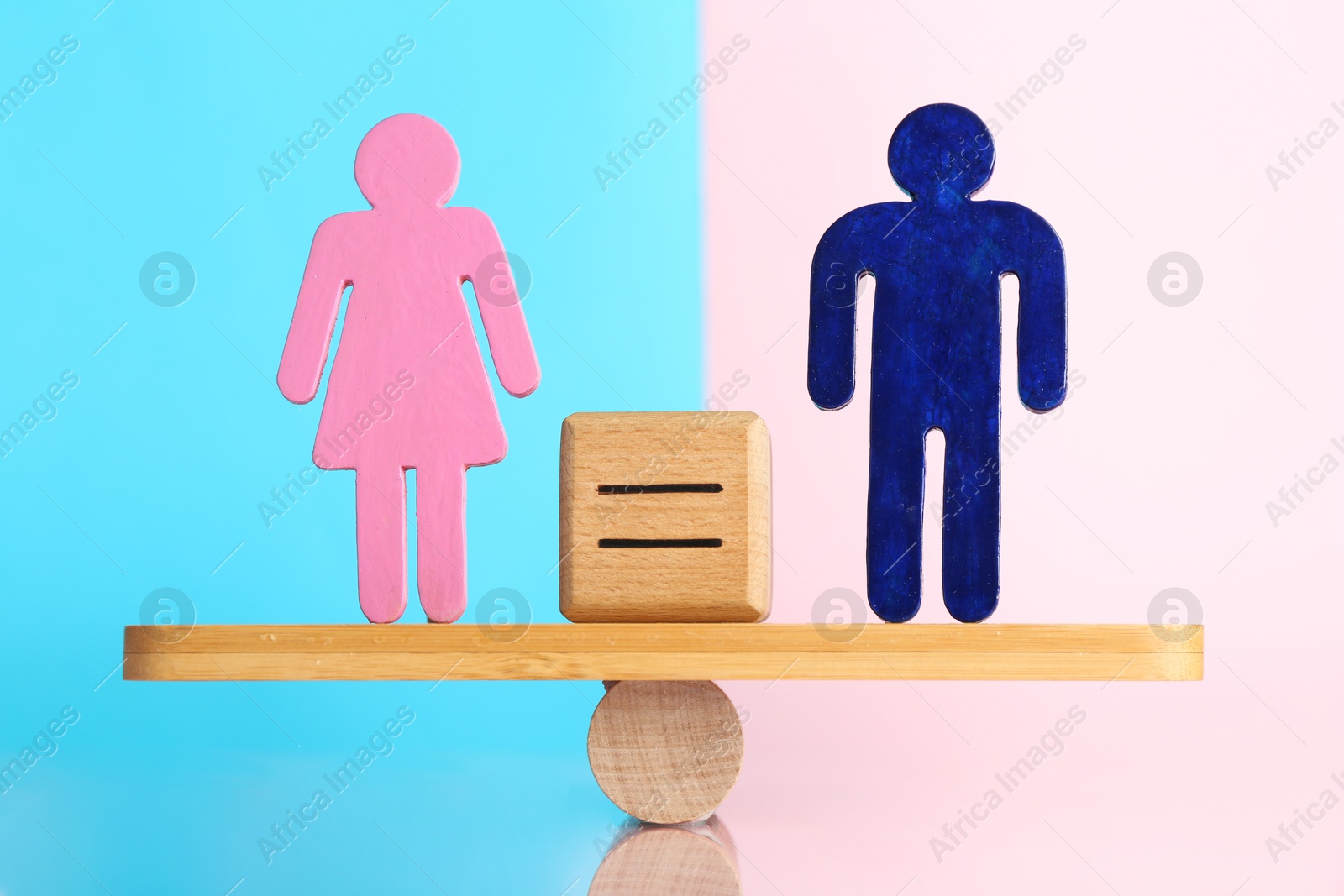 Photo of Gender equality concept. Cube with equals sign between male and female figures on scales against color background