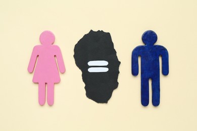 Photo of Gender equality concept. Male and female figures on beige background, flat lay