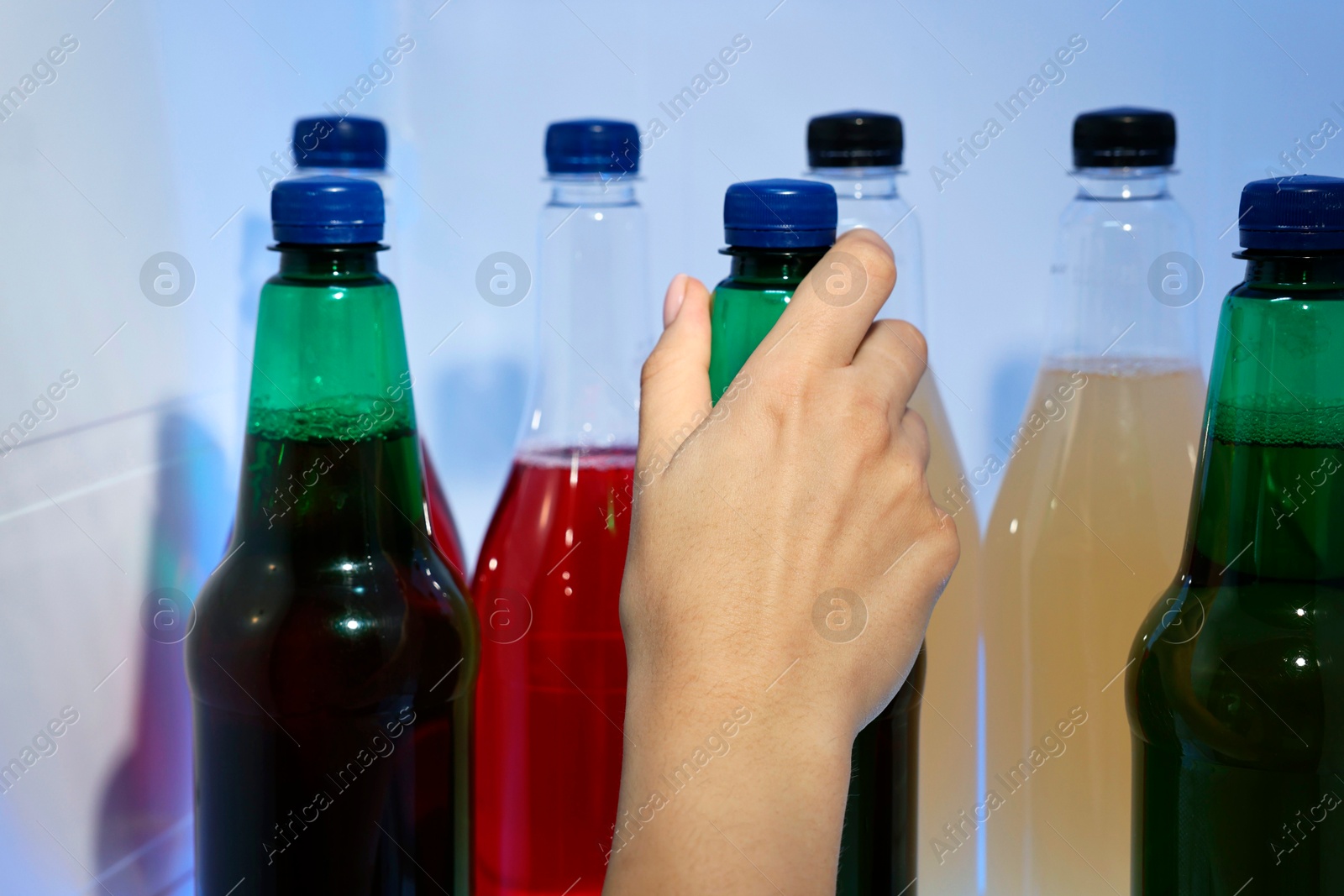 Photo of Woman taking bottle with drink from refrigerator, closeup