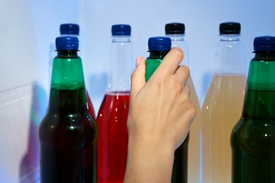 Photo of Woman taking bottle with drink from refrigerator, closeup