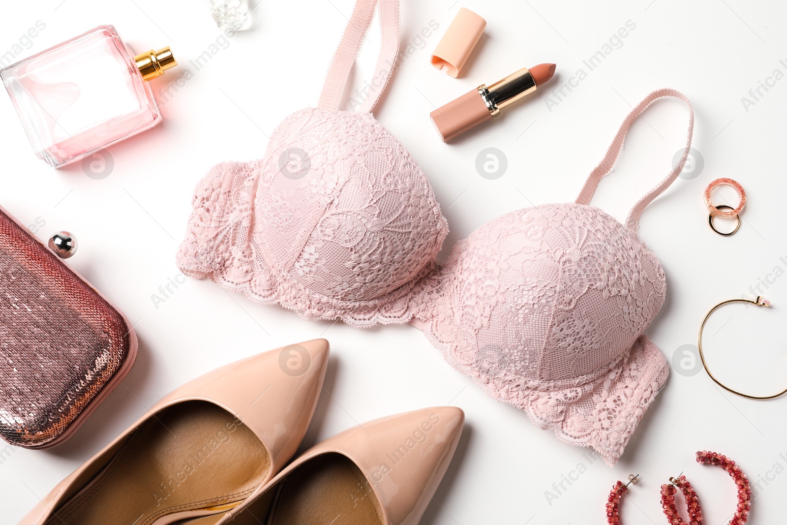 Photo of Beautiful lace bra and accessories on white background, flat lay