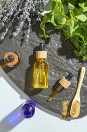 Photo of Tinctures in bottles and medicinal herbs on white table, top view